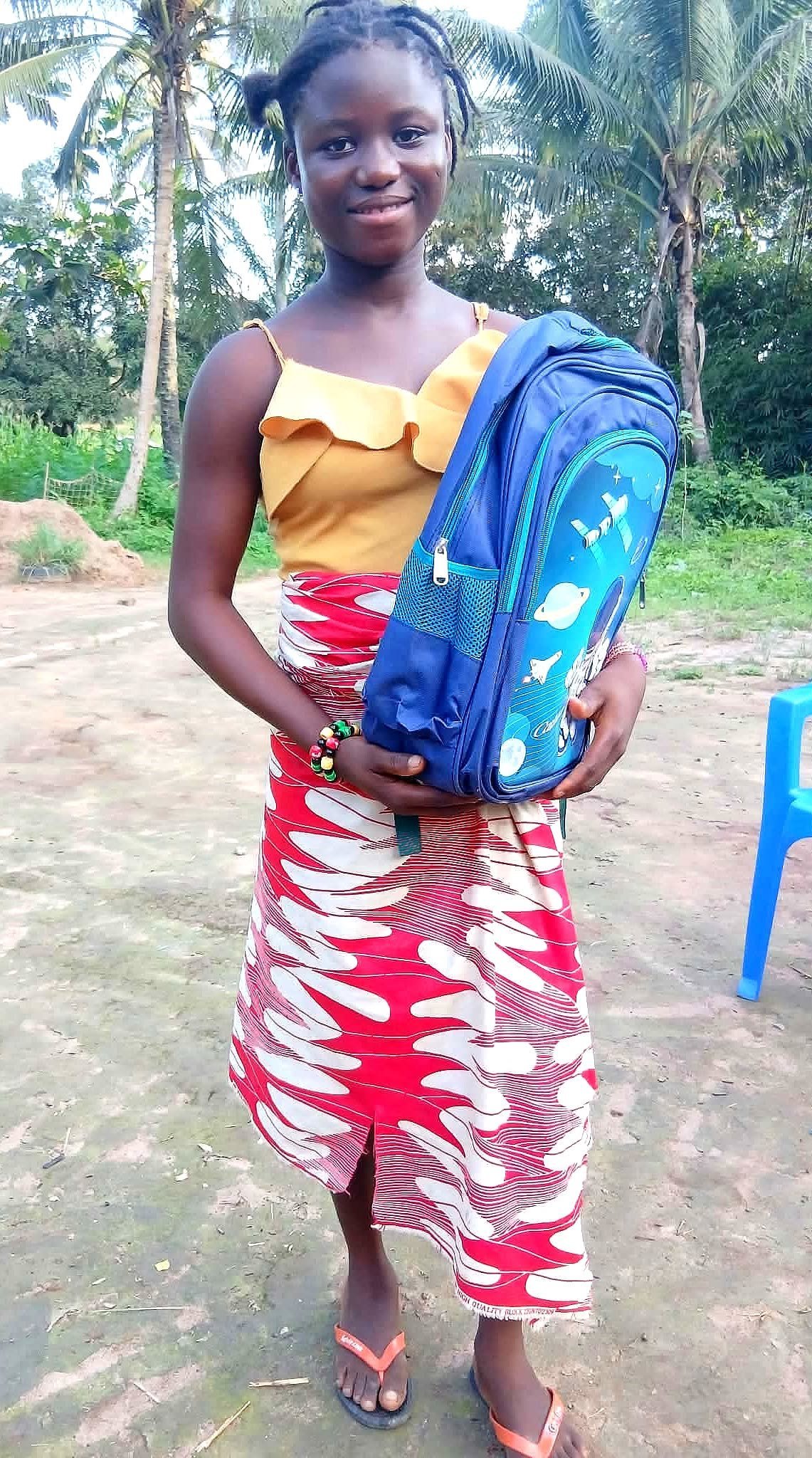Escolar mostrando su mochila azul al inicio del curso en Diassia